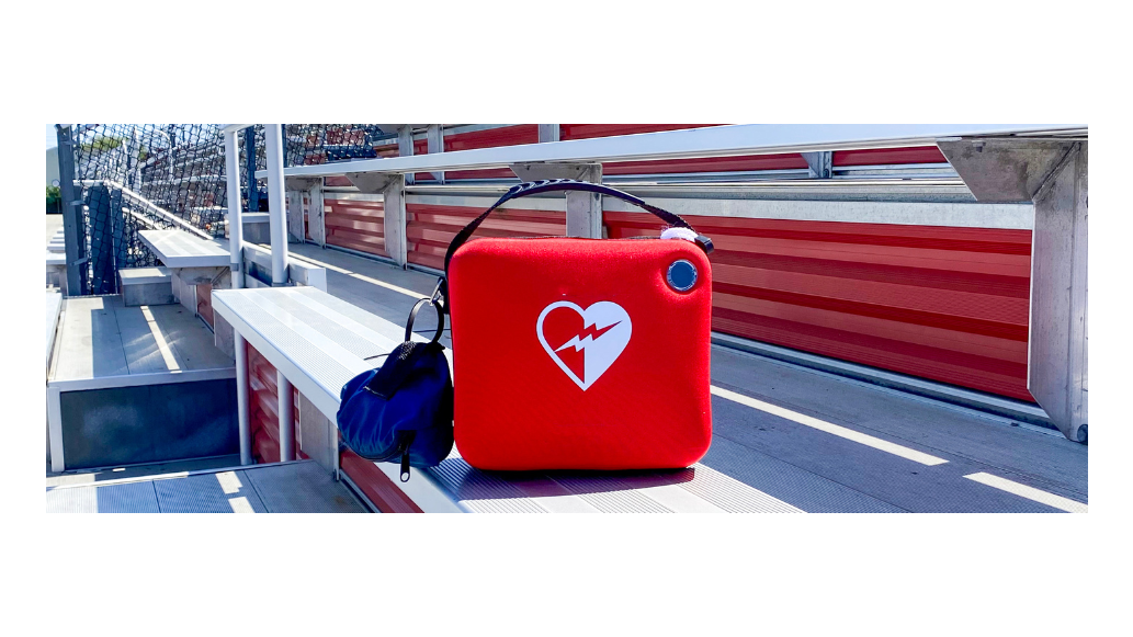 An AED box sitting on outdoor bleachers