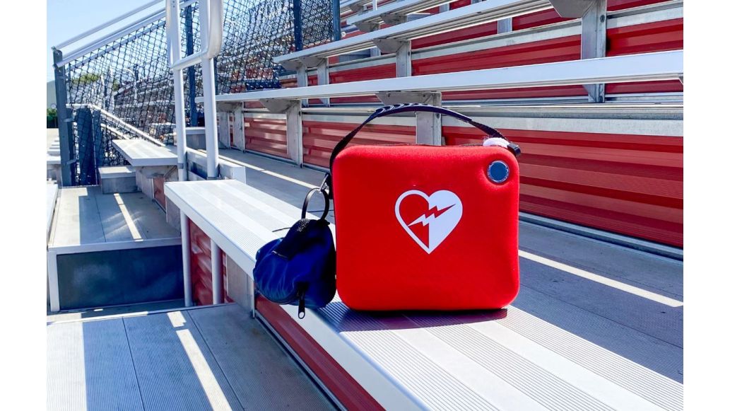An AED box sitting on outdoor bleachers