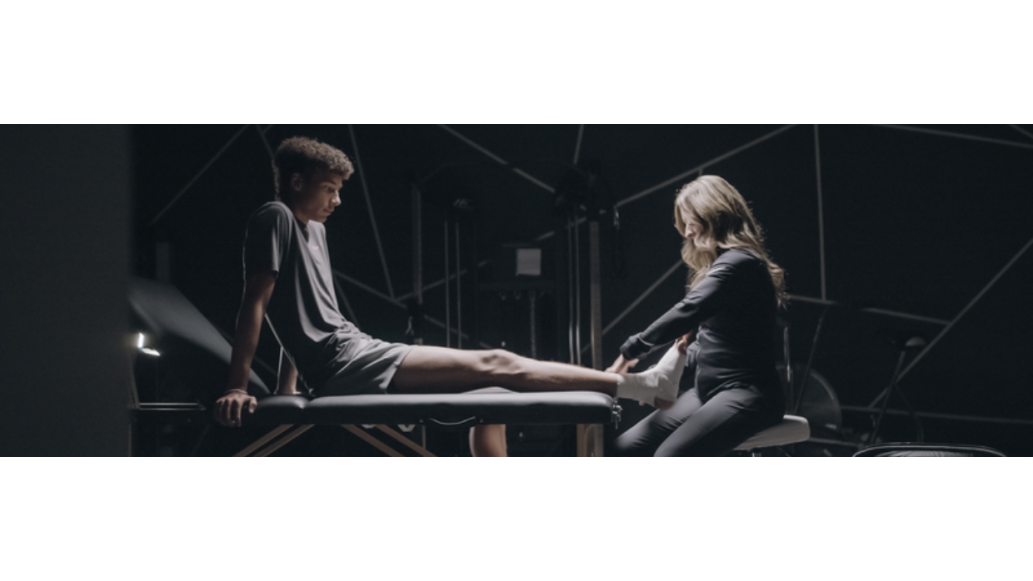 athletic trainer taping athlete's ankle
