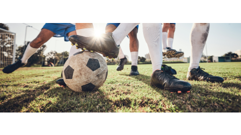 A view of soccer players' feet play for a soccer ball