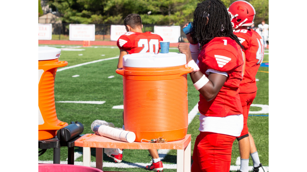 football player takes a drink from a cup